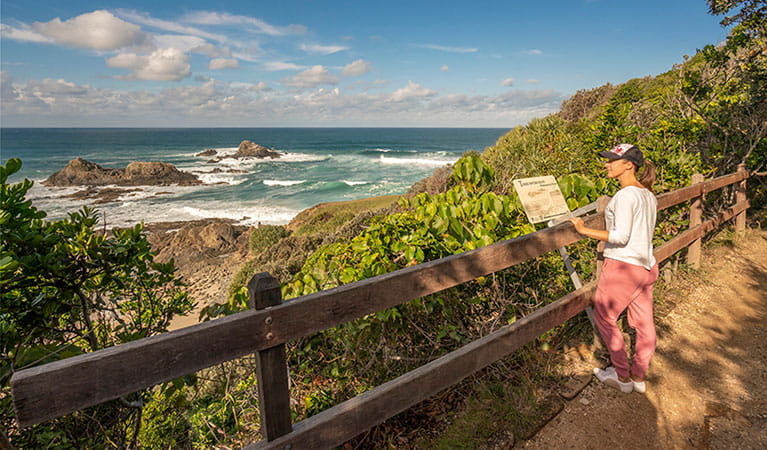 Photo of a person overlooking the Three Sisters while learning about their history from a track informational sign